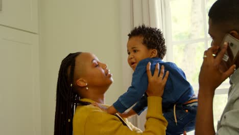 Side-view-of-young-black-mother-playing-with-her-baby-in-a-comfortable-home-4k