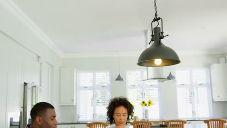 Black-family-praying-together-before-having-food-at-home-4k