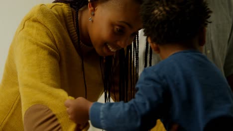 Side-view-of-young-black-mother-playing-with-her-son-in-a-comfortable-home-4k