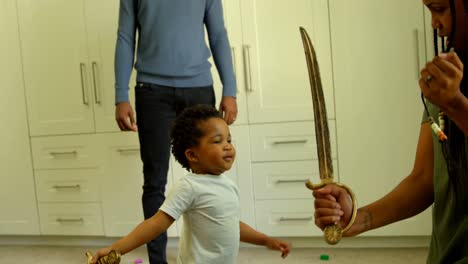 Side-view-of-young-black-mother-and-son-playing-with-toy-sword-in-a-comfortable-home-4k