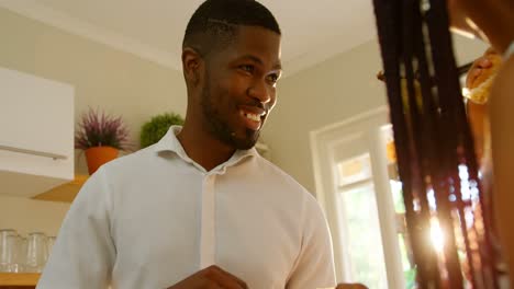 Front-view-of-young-black-father-smiling-and-looking-his-son-in-kitchen-of-comfortable-home-4k
