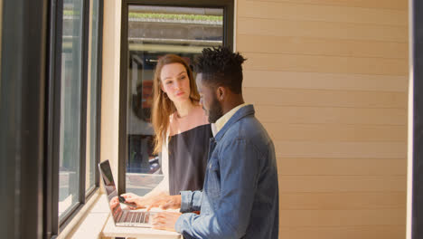 Side-view-of-young-mixed-race-business-team-planning-and-standing-near-window-of-modern-office-4k