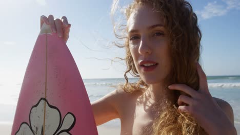Surfista-Femenina-Parada-Con-Tabla-De-Surf-En-La-Playa-4k