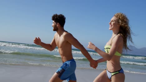 Romantic-couple-running-together-at-beach-4k