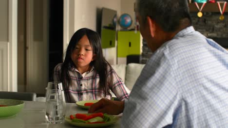Cute-asian-granddaughter-and-old-senior-grandfather-eating-food-in-a-comfortable-home-4k