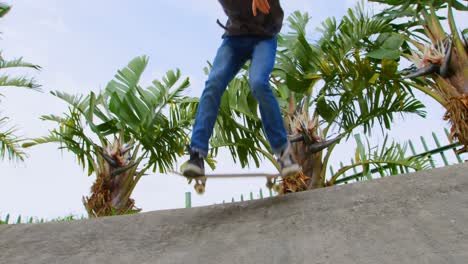 Low-Angle-Ansicht-Eines-Jungen-Kaukasischen-Mannes,-Der-Auf-Der-Rampe-Im-Skateboardpark-Einen-Skateboard-Trick-Macht,-4k