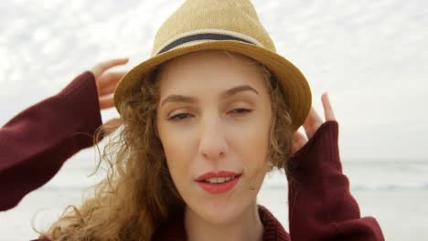 Front-view-of-young-beautiful-caucasian-woman-in-hat-on-the-beach-4k