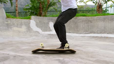 Side-view-of-young-caucasian-man-practicing-skateboarding-trick-on-ramp-in-skateboard-park-4k
