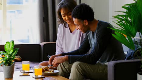 Side-view-of-mixed-race-young-couple-discussing-on-mobile-phone-in-a-comfortable-home-4k
