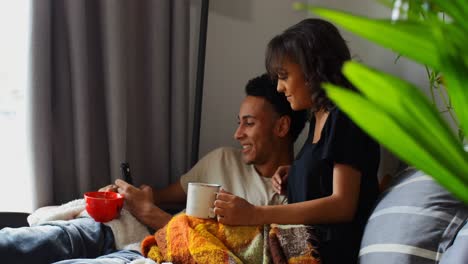 Seitenansicht-Eines-Jungen-Asiatischen-Paares,-Das-Miteinander-Interagiert-Und-Zu-Hause-Im-Wohnzimmer-Kaffee-Trinkt