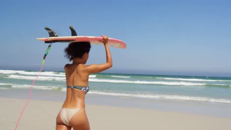 Woman-running-with-surfboard-at-beach-4k