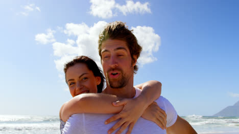 Front-view-of-young-caucasian-couple-having-fun-at-beach-on-a-sunny-day-4k