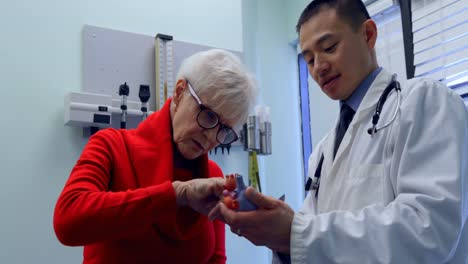 Junger-Asiatischer-Arzt-Und-älterer-Patient-Diskutieren-über-Das-Herzmodell-In-Der-Klinik-4k