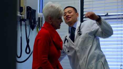 Seitenansicht-Eines-Jungen-Asiatischen-Arztes,-Der-Einen-älteren-Patienten-In-Der-Klinik-Untersucht-4k
