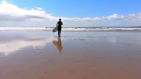 Männlicher-Surfer,-Der-An-Einem-Sonnigen-Tag-Mit-Surfbrett-Am-Strand-Spaziert-4k