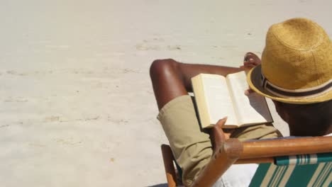 Man-reading-a-book-at-beach-4k