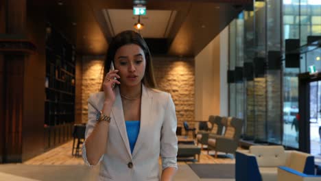 Mujer-De-Negocios-Hablando-Por-Teléfono-Móvil-En-La-Oficina-4k