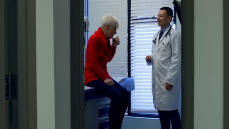 Young-Asian-male-doctor-interacting-with-senior-patient-in-the-clinic-4k