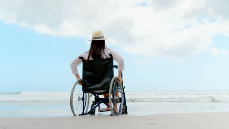 Rückansicht-Einer-Behinderten-Frau,-Die-Im-Rollstuhl-Am-Strand-Sitzt-4k