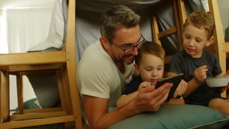 Vorderansicht-Eines-Kaukasischen-Vaters-Und-Seiner-Kinder,-Die-Ein-Digitales-Tablet-In-Einem-Komfortablen-Zuhause-Nutzen,-4K