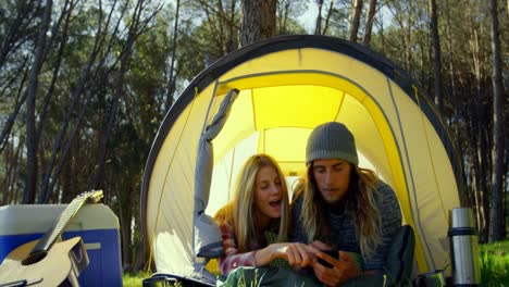 Young-couple-discussing-over-mobile-phone-in-tent-4k