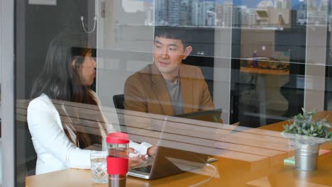 Jóvenes-Empresarios-Asiáticos-Interactuando-Entre-Sí-En-La-Oficina-4k