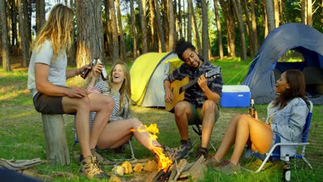 Friends-having-fun-near-bonfire-in-the-forest-4k
