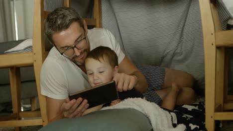 Front-view-of-caucasian-father-and-son-using-digital-tablet-in-a-comfortable-home-4k