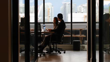 Side-view-of-young-Asian-business-colleagues-interacting-with-each-other-in-modern-office-4k