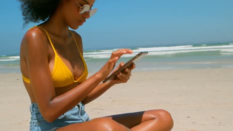 Hermosa-Joven-Afroamericana-Usando-Tableta-Digital-En-La-Playa-Bajo-El-Sol-4k