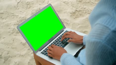 Woman-using-laptop-on-beach-4k