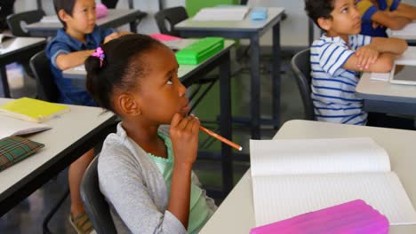 Multi-ethnic-school-kids-studying-at-desk-in-classroom-at-school-4k