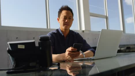 Ejecutivo-Masculino-De-Negocios-Asiático-Usando-Teléfono-Móvil-En-El-Escritorio-En-La-Oficina-4k