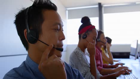 Multiethnische-Kundenvertriebsleiter-Sprechen-über-Headset-In-Modernen-Büros-In-4K