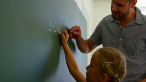 Schoolgirl-solving-mathematical-equation-on-chalkboard-in-classroom-4k