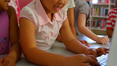 Schulmädchen-Lernen-Gemeinsam-Am-Laptop-Am-Tisch-In-Der-Schulbibliothek-4k