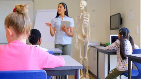 Asian-female-teacher-explaining-about-skeleton-model-in-classroom-4k