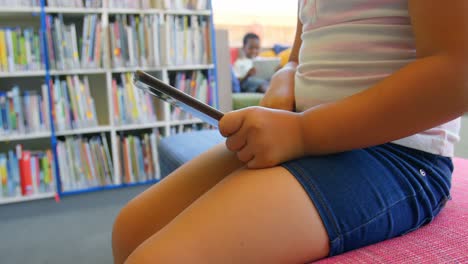 Schoolgirl-studying-on-digital-tablet-in-school-library-4k