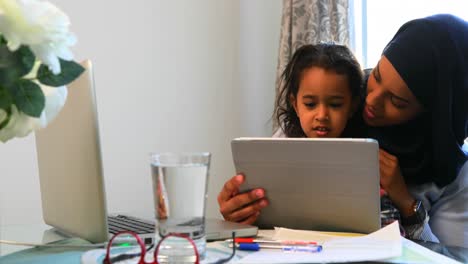 Junge-Mutter-Nutzt-Ein-Digitales-Tablet-Mit-Ihrer-Tochter-Auf-Dem-Tisch-4k