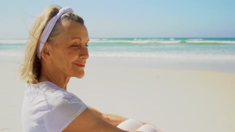 Vista-Lateral-De-Una-Mujer-Caucásica-Senior-Activa-Realizando-Yoga-En-La-Playa-4k