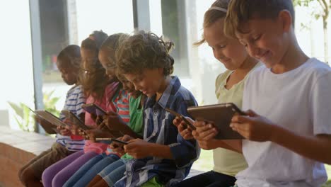 Seitenansicht-Von-Gemischtrassigen-Schulkindern,-Die-Ein-Digitales-Tablet-Im-Flur-Nutzen,-4K