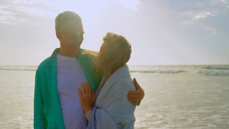 Active-senior-Caucasian-couple-embracing-each-other-on-the-beach-4k