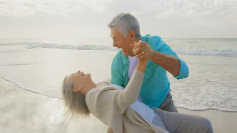 Aktives-Seniorenpaar-Tanzt-Gemeinsam-Am-Strand-4k