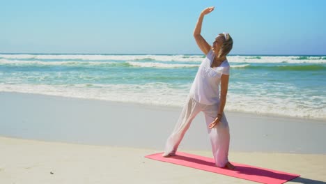 Vorderansicht-Einer-Aktiven-älteren-Kaukasischen-Frau,-Die-Am-Strand-Yoga-Macht,-4k