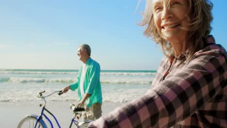 Pareja-Caucásica-Senior-Activa-Parada-Con-Bicicleta-En-La-Playa-4k