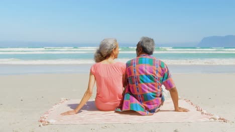 Rückansicht-Eines-Aktiven-älteren-Afroamerikanischen-Paares,-Das-Sich-Auf-Einer-Decke-In-Der-Sonne-Am-Strand-Entspannt,-4k