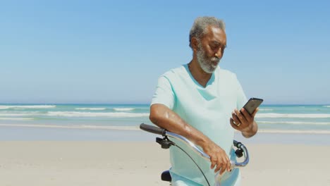 Vista-Frontal-De-Un-Hombre-Afroamericano-Senior-Activo-Tomando-Selfie-Con-Teléfono-Móvil-En-La-Playa-4k