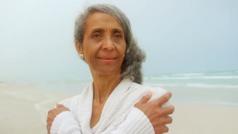 Vista-Frontal-De-Una-Mujer-Afroamericana-Senior-Activa-Y-Pensativa-Temblando-En-La-Playa-4k