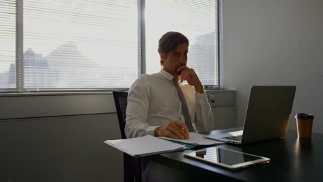 Vorderansicht-Einer-Jungen-Kaukasischen-Männlichen-Führungskraft,-Die-Am-Laptop-Am-Schreibtisch-In-Einem-Modernen-Büro-In-4K-Arbeitet