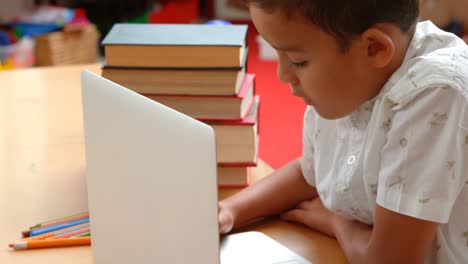 Seitenansicht-Eines-Aufmerksamen-Asiatischen-Schülers,-Der-Mit-Laptop-In-Einem-Klassenzimmer-In-Der-Schule-4k-Lernt